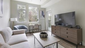 salon z telewizorem, kanapą i stołem w obiekcie Landing - Modern Apartment with Amazing Amenities (ID1403X372) w mieście Portland