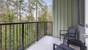 weranda z 2 krzesłami i poręczą z drzewami w obiekcie Landing - Modern Apartment with Amazing Amenities (ID1403X372) w mieście Portland