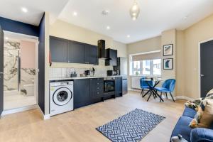uma cozinha e sala de estar com máquina de lavar e secar roupa em Modern 1 bed close to town and station em Worthing