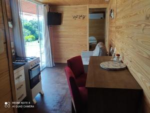 a kitchen with a table and a stove and a room at Casa Container Amarela in Bagé