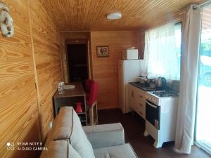 ein Wohnzimmer mit einem Sofa und einer Küche in der Unterkunft Casa Container Amarela in Bagé
