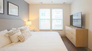 1 dormitorio con 1 cama, TV y 2 ventanas en Landing Modern Apartment with Amazing Amenities (ID2613X64) en Detroit
