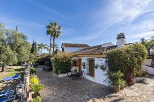 Casa blanca con patio y palmeras en La Granja de Antonio, en Alhaurín el Grande