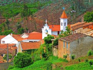 una pequeña ciudad con una iglesia en una colina en One bedroom house with terrace and wifi at Miranda do Corvo, en Vale de Colmeias