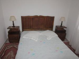 una camera da letto con un letto grande con due comodini di Charming house in Miranda do Corvo + Spacious terrace a Vale de Colmeias