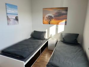 a room with two beds and a picture on the wall at Ferienwohnung Hommelshof in Korschenbroich