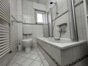 a white bathroom with a toilet and a sink at Ferienwohnung Hommelshof in Korschenbroich