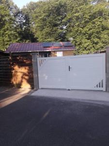 a garage with a white gate and a house at Chalet d'une chambre avec terrasse et wifi a Les Breviaires in Les Bréviaires