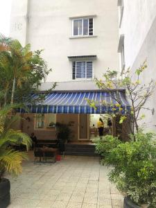 a building with a blue awning in a courtyard at SARAH HOMESTAY in Thôn Lại Thê