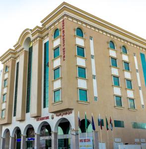 un gran edificio con banderas delante en Doha Dynasty Hotel, en Doha