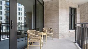休斯頓的住宿－Landing Modern Apartment with Amazing Amenities (ID9007X63)，阳台配有2把椅子和1张桌子