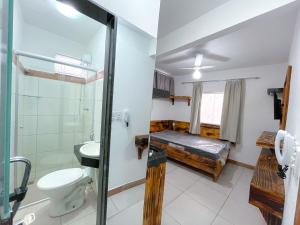 uma casa de banho com uma cama, um chuveiro e um WC. em Suíte aconchegante no Centro de Caratinga - kitnet em Caratinga