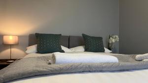 a large bed with two pillows on top of it at The Deeside in Buckley