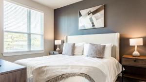 um quarto com uma grande cama branca e 2 candeeiros em Landing Modern Apartment with Amazing Amenities (ID7345X71) em Austin