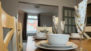 a dining room table with plates and glasses on it at The Deeside in Buckley