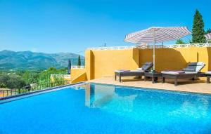 einen Pool mit 2 Stühlen und einem Sonnenschirm in der Unterkunft casa del bosque in Orba