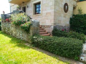 une maison avec un mur en pierre, des escaliers et des fleurs dans l'établissement 2 bedrooms chalet with terrace and wifi at Orena, à Oreña