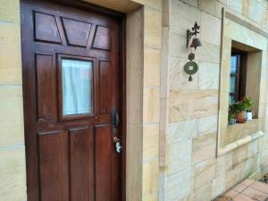 a wooden door on a house with a stone wall at 2 bedrooms chalet with terrace and wifi at Orena in Oreña