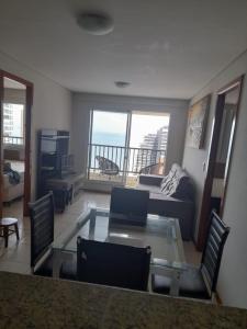 un soggiorno con tavolo in vetro e divano di Villa damasco a Fortaleza