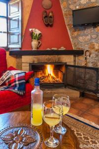 two glasses of wine on a table in front of a fireplace at 2 bedrooms chalet with terrace and wifi at Orena in Oreña