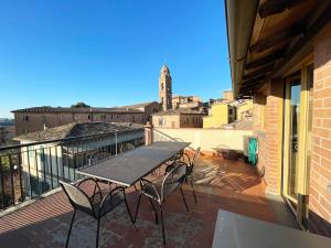 a patio with a table and chairs on a balcony at Casa della Chiocciola: In Centro in Siena