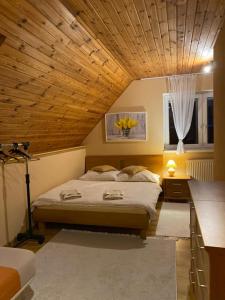 Schlafzimmer mit einem Bett mit Holzdecke in der Unterkunft Apartmánový dom Anna in Stará Lesná