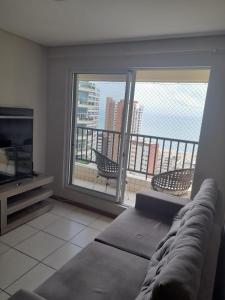 a living room with a couch and a large window at Villa damasco in Fortaleza