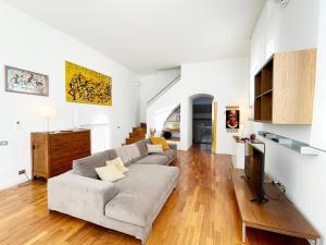 a living room with a couch and a tv at Casa della Chiocciola: In Centro in Siena
