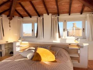 a bedroom with a bed with a yellow pillow at Casa della Chiocciola: In Centro in Siena