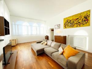 a living room with a couch and a painting on the wall at Casa della Chiocciola: In Centro in Siena