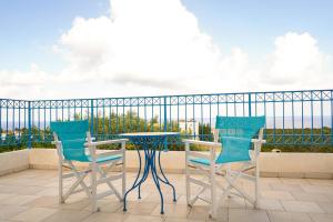 two chairs and a table on a balcony at Azzurro Holiday Villas in Peyia