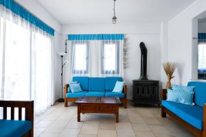 sala de estar con sofás azules y fogones en Azzurro Holiday Villas, en Peyia