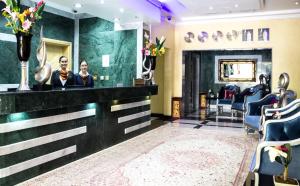 a salon with a man and a woman sitting at a bar at Doha Dynasty Hotel in Doha