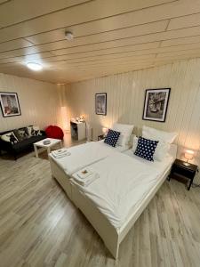 1 dormitorio con 1 cama blanca grande y 1 sofá en Quartier Wenzelnberg work&stay en Langenfeld