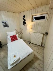 a bedroom with a bed with a red pillow at Quartier Wenzelnberg work&stay in Langenfeld