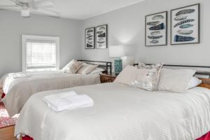 2 łóżka w pokoju z białymi ścianami w obiekcie Home In The Heart Of Watkins Glen With Hot Tub And Game Rm w mieście Watkins Glen
