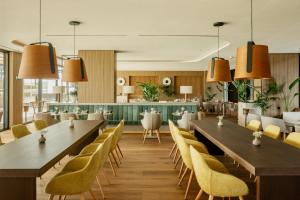 a restaurant with tables and chairs and a bar at Torre Melina, a Gran Meliá Hotel in Barcelona