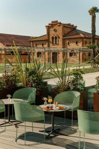 a patio with chairs and a table and a building at Torre Melina, a Gran Meliá Hotel in Barcelona