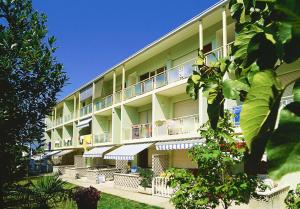 a large apartment building with balconies and plants at Appartamenti Ai Pini in Bibione