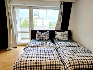 1 cama con 2 almohadas en una habitación con ventana en 2 bedrooms appartement with balcony and wifi at Auerbach Bensheim 