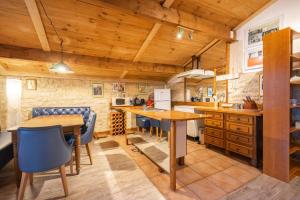 eine Küche mit Holzdecken sowie Holztischen und -stühlen in der Unterkunft L'arbre - Gîtes De La Tournerie in Gémozac