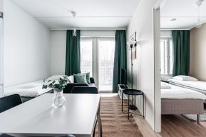 a hotel room with two beds and a table at SPOT Apartments Hämeenlinna in Hämeenlinna