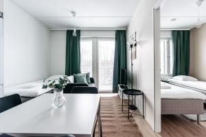 ハメーンリンナにあるSPOT Apartments Hämeenlinnaのベッド2台とテーブルがあるホテルの部屋