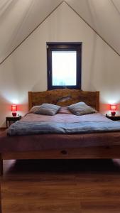 Schlafzimmer mit einem großen Bett und einem Fenster in der Unterkunft Domek pod Żukowem in Ustrzyki Dolne