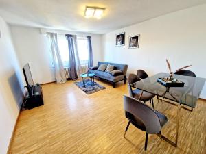 a living room with a couch and a table and chairs at 2 bedrooms appartement with balcony and wifi at Neckarau Mannheim in Neckarau