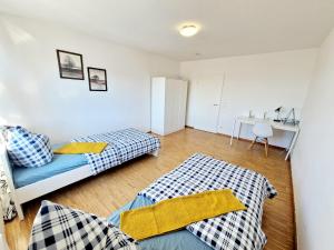 a bedroom with two beds and a desk at 2 bedrooms appartement with balcony and wifi at Neckarau Mannheim in Neckarau