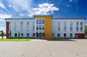 ein großes weißes Gebäude mit vielen Fenstern in der Unterkunft Median Hotel Hannover Lehrte in Lehrte