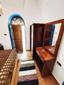 a room with a dresser and a mirror and a bed at Villa Cleopatra Luxor west bank in Luxor