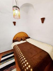 1 dormitorio con cama grande de madera y lámpara de araña en Villa Cleopatra Luxor west bank en Luxor