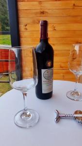 a bottle of wine and two wine glasses on a table at NaturaLove Glamping Mongui in Monguí